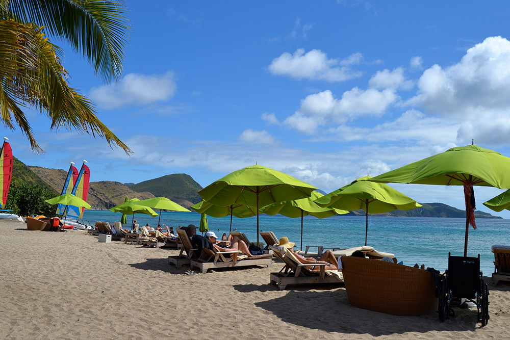 Green umbrellas under the blue skies on a Caribbean beach